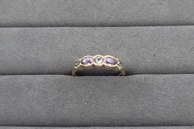 Lot 61 - A TOPAZ AND AMETHYST SET FIVE STONE BAND RING,...