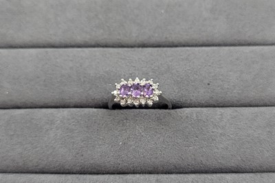 Lot 63 - AN AMETHYST AND DIAMOND CLUSTER RING, the trio...