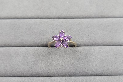 Lot 65 - AN AMETHYST DAISY STYLE CLUSTER RING, the oval...