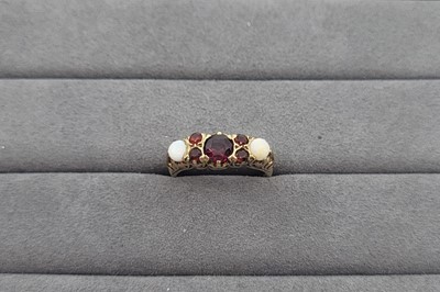 Lot 71 - A GARNET AND OPAL SET SEVEN STONE RING, the...