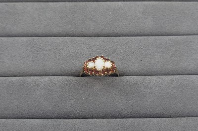 Lot 72 - A GARNET AND OPAL SET CLUSTER RING, the trio...