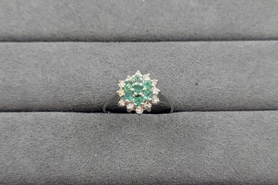 Lot 83 - AN EMERALD AND DIAMOND CLUSTER RING, the...