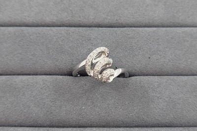 Lot 104 - A DIAMOND CLUSTER RING, of abstract swirl...