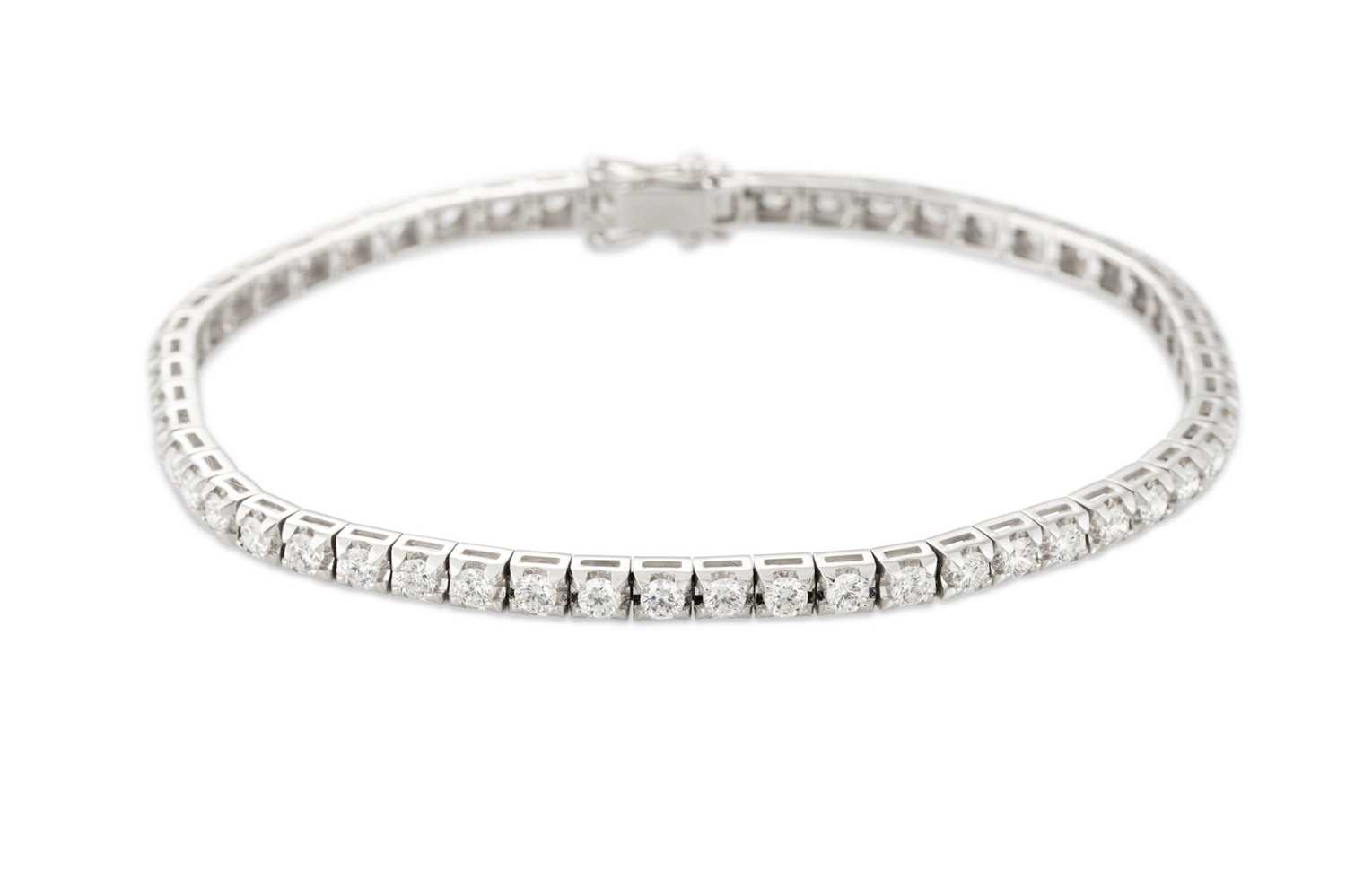 Lot 289 - A DIAMOND LINE BRACELET, the brilliant cut...
