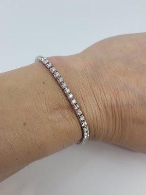 Lot 289 - A DIAMOND LINE BRACELET, the brilliant cut...