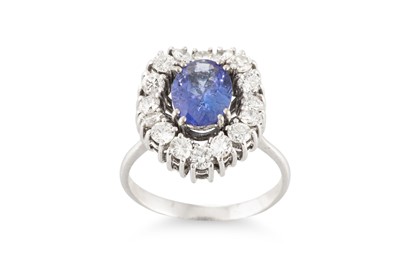 Lot 182 - A TANZANITE AND DIAMOND CLUSTER RING, the oval...