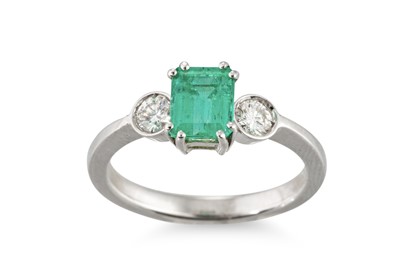 Lot 211 - AN EMERALD AND DIAMOND THREE STONE RING, the...