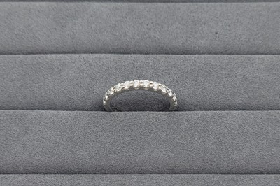 A DIAMOND HALF ETERNITY RING, the round...