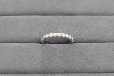 A DIAMOND SET HALF ETERNITY RING, the round...