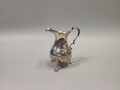 Lot 531 - A GEORGE II SILVER CREAM JUG, embossed design,...