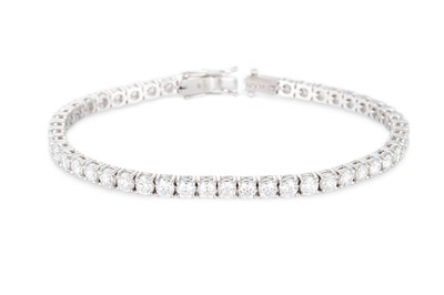 Lot 323 - A DIAMOND LINE BRACELET, the brilliant cut...
