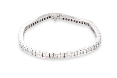 Lot 374 - A DIAMOND LINE BRACELET, the princess cut...