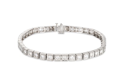 Lot 222 - A DIAMOND LINE BRACELET, mounted in platinum...