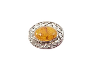 Lot 140 - AN OVAL AMBER BROOCH, mounted in silver