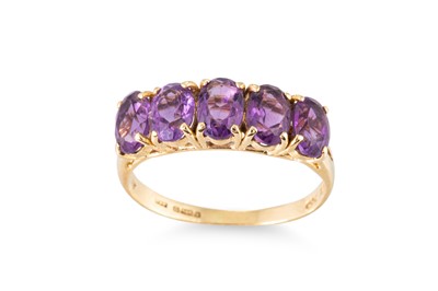 Lot 59 - AN AMETHYST FIVE STONE RING, the oval cut...