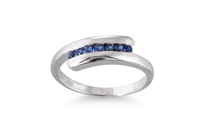 Lot 64 - A SAPPHIRE SET CROSS-OVER STYLE RING, the...