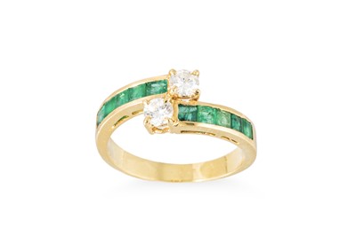 Lot 186 - A DIAMOND AND EMERALD CROSS-OVER RING,...