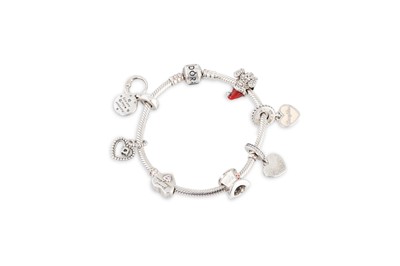 Lot 9 - A PANDORA CHARM BRACELET, with seven charms...