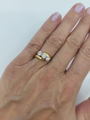 Lot 15 - A DIAMOND THREE STONE RING, the crossover...