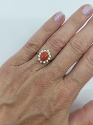 Lot 28 - A CORAL AND PEARL CLUSTER RING, the central...