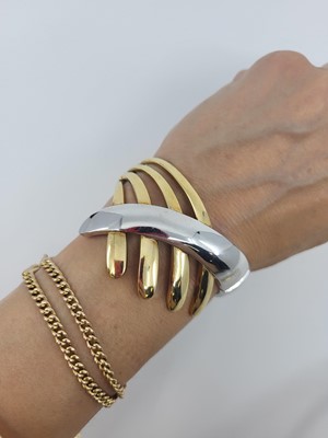 Lot 128 - AN 18CT YELLOW & WHITE GOLD BANGLE, hinged,...