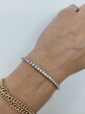 Lot 50 - A DIAMOND LINE BRACELET, the brilliant cut...