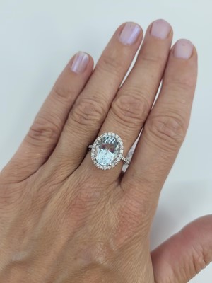 Lot 44 - AN AQUAMARINE AND DIAMOND RING, the oval...