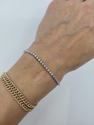 Lot 45 - A DIAMOND LINE BRACELET, the brilliant cut...