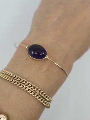 Lot 46 - AN AMETHYST BANGLE, the cabochon amethyst to...