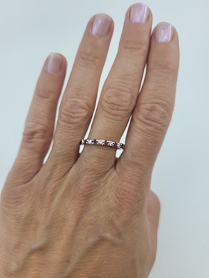 Lot 171 - A DIAMOND AND RUBY FULL ETERNITY RING, mounted...