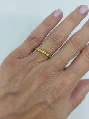 Lot 66 - A YELLOW SAPPHIRE FULL BANDED ETERNITY RING,...