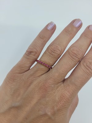 Lot 67 - A RUBY FULL BANDED ETERNITY RING, mounted in...