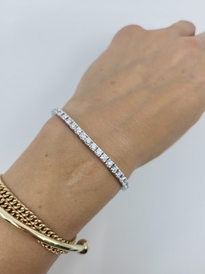 Lot 284 - A DIAMOND LINE BRACELET, the brilliant cut...