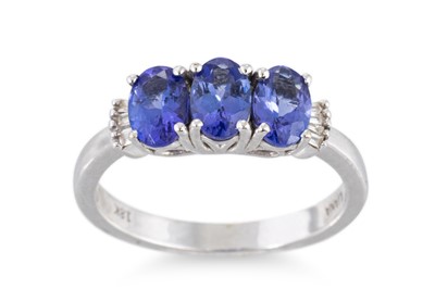 Lot 67 - A THREE STONE TANZANITE RING, the three oval...