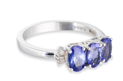 Lot 67 - A THREE STONE TANZANITE RING, the three oval...