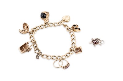 Lot 49 - A 9CT YELLOW GOLD CHARM BRACELET, set with...