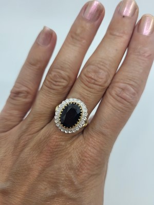Lot 22 - A DIAMOND AND SAPPHIRE CLUSTER RING, the oval...