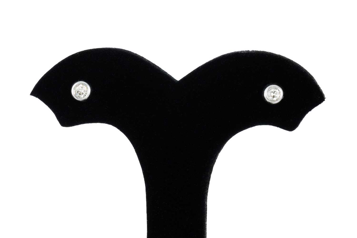 Lot 23 - A PAIR OF DIAMOND STUD EARRINGS, the bezel set...