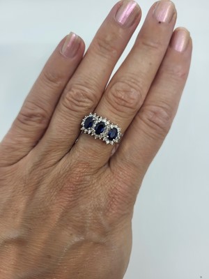 Lot 26 - A DIAMOND AND SAPPHIRE THREE STONE CLUSTER...