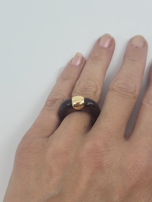 Lot 84 - AN UNUSUAL GOLD & RESIN SET RING, the resin...
