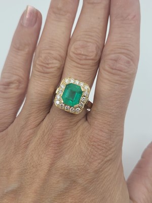 Lot 85 - AN EMERALD AND DIAMOND SET CLUSTER RING, the...