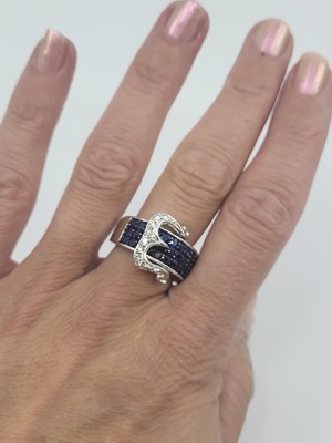 Lot 87 - A SAPPHIRE AND DIAMOND BUCKLE STYLE RING, the...