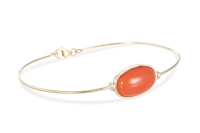 Lot 59 - A CORAL SET BANGLE, the bezel set cabochon...