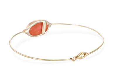 Lot 59 - A CORAL SET BANGLE, the bezel set cabochon...