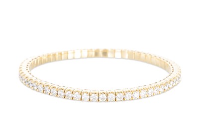 Lot 295 - A DIAMOND BANGLE, of flexible form, the...