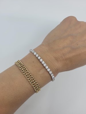 Lot 397 - A DIAMOND LINE BRACELET, the brilliant cut...