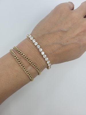 Lot 401 - A DIAMOND LINE BRACELET, the brilliant cut...