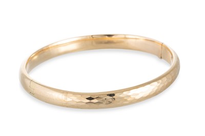 Lot 26 - A YELLOW GOLD HINGED BANGLE, of hollow form,...
