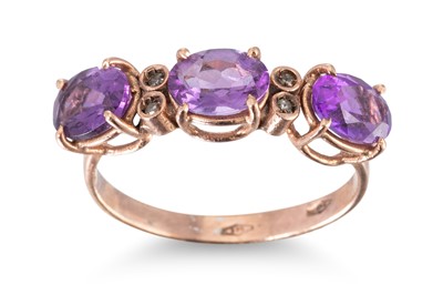 Lot 244 - AN AMETHYST THREE STONE RING, the oval...