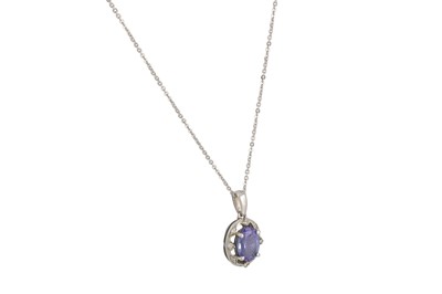 Lot 99 - A TANZANITE AND DIAMOND CLUSTER PENDANT, in...